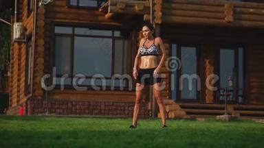 一位身材苗条、穿着运动服的美女正准备在她附近的草坪上开始训练